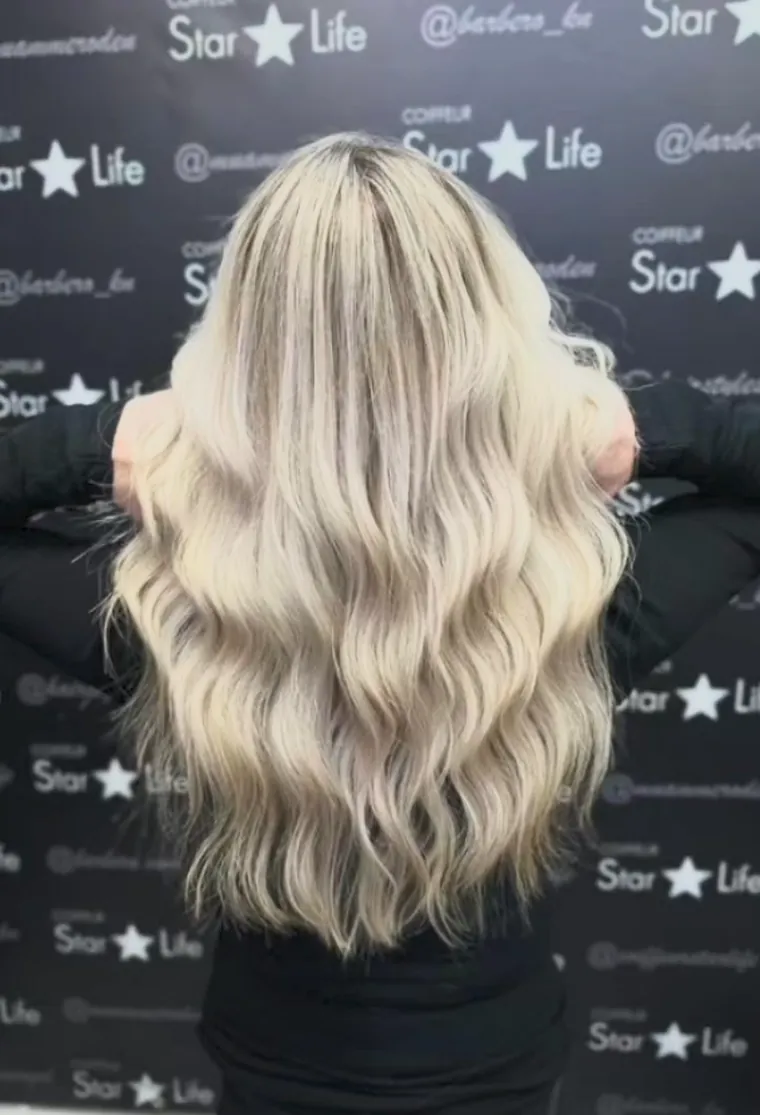 Lange blonde Wellen vor der Salonwand, Coiffeur Star Life Merkstein
